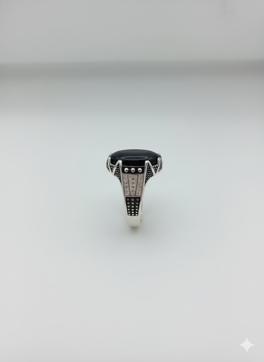 Silver ring with a black gemstone on a white background